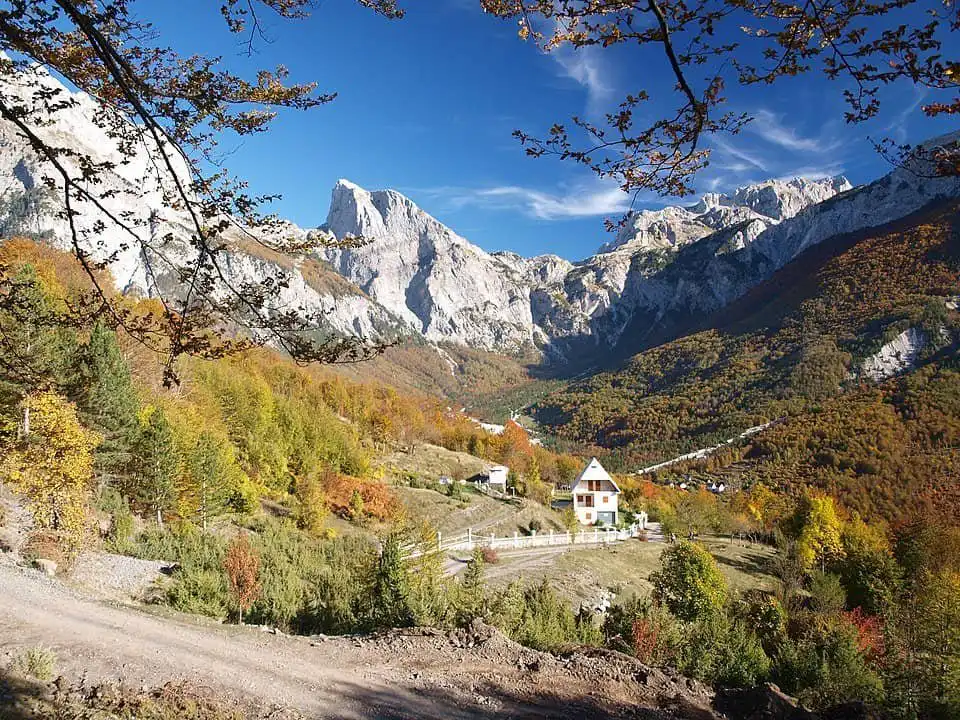 Alpine village nestled in the mountains with colourful fall foliage.