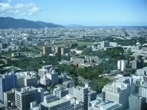 Vibrant city skyline with lush green parks and modern buildings in Hokkaido, Japan.