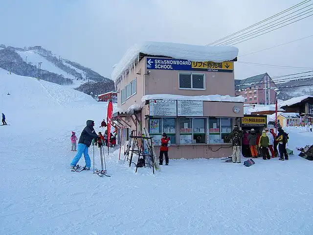 Ski school in Hokkaido with skiers and snowboarders preparing for winter adventures.