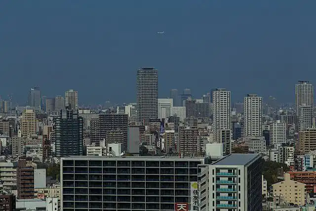 Night view of Osaka city skyline with tall buildings and clear sky.